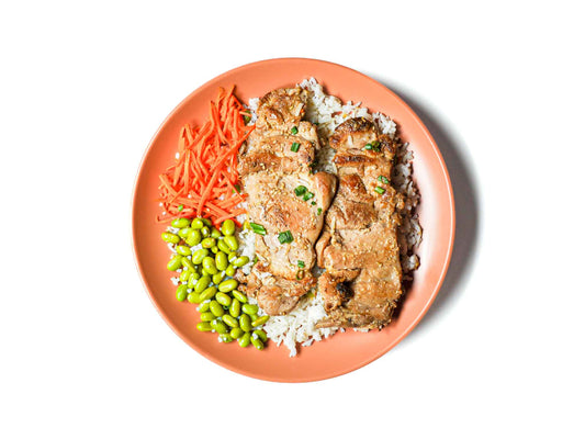 Buddha Bowls' Teriyaki Chicken Coconut Bowl features tender teriyaki-glazed chicken served over fragrant coconut rice. Paired with fresh edamame beans and sweet carrots, this dish combines sweet, savory, and refreshing flavors for a deliciously balanced and satisfying meal.