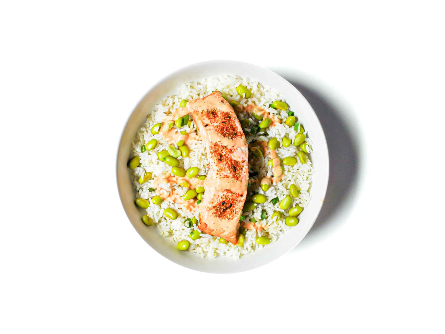 Viral Eats Kitchen's viral inspired Kewpie Salmon Bowl features flaked salmon topped with creamy Kewpie mayo, siracha and soy sauce served over a bed of jasmine rice. Paired with fresh edamame beans, this dish delivers a light and flavorful combination of savory, creamy, and wholesome ingredients for a delightful meal.