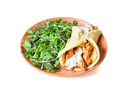 Sumac's Chicken Gyro Wrap features tender, marinated chicken wrapped in soft pita bread with peppery arugula and creamy tzatziki sauce. This flavorful combination offers a fresh and satisfying take on a Mediterranean classic.