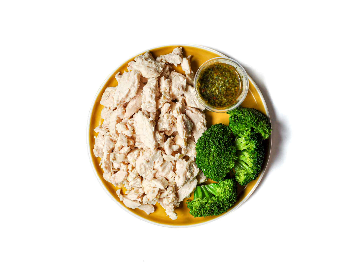 Roli Roti's Double Sous-Vide Chicken and Broccoli Bowl features succulent chicken, steamed broccoli, and a refreshing chimichurri sauce.